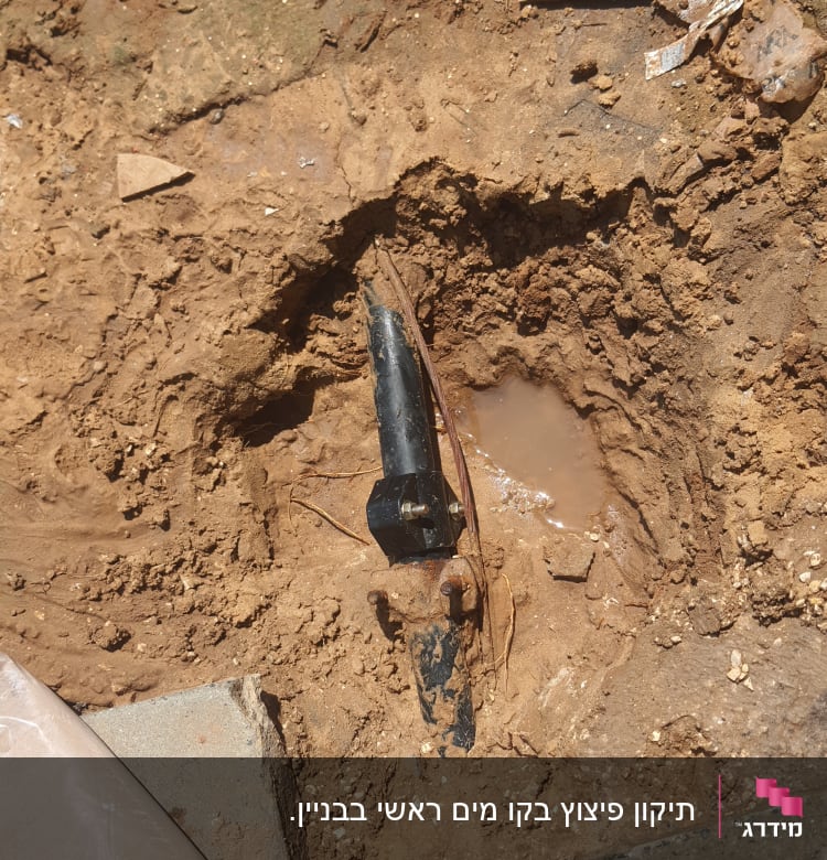 צינור שבור באדמה עם מים מסביב